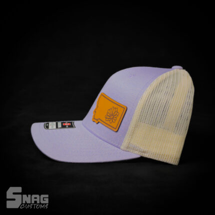 Montana state outline with hand drawn bitterroot flower inset within border, leather patch hat